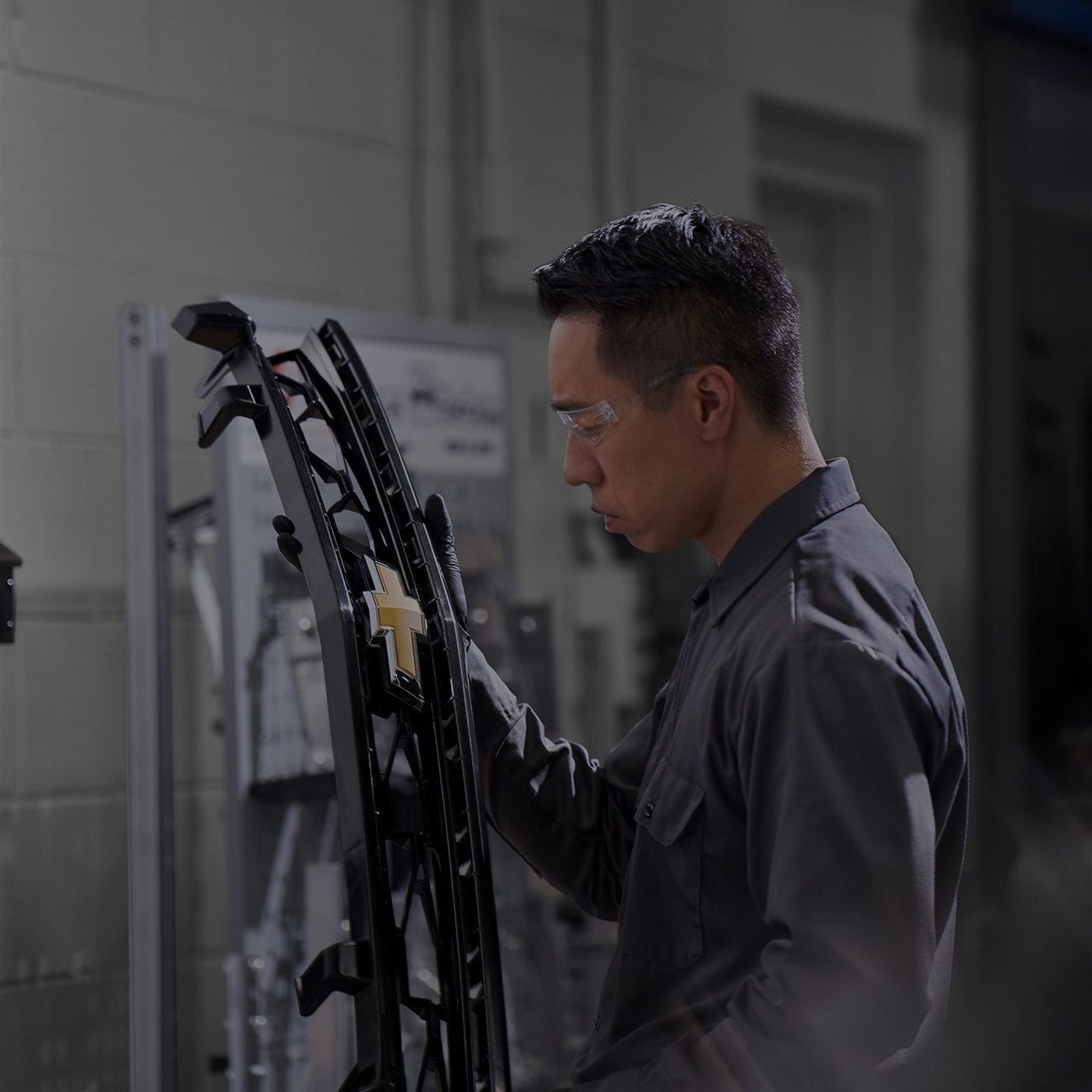 Chevrolet technician in a parts area handling a vehicle trim component