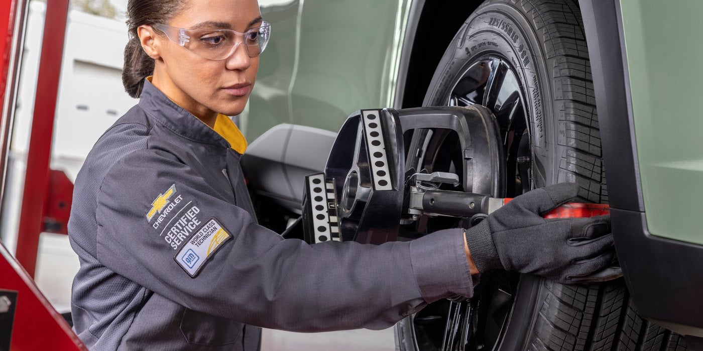 Chevrolet Certified Service technician mounting an alignment sensor on a wheel