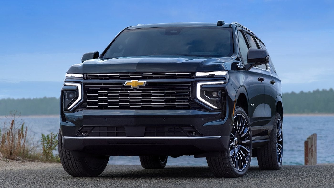 Black Chevrolet Suburban front view parked beside a lake