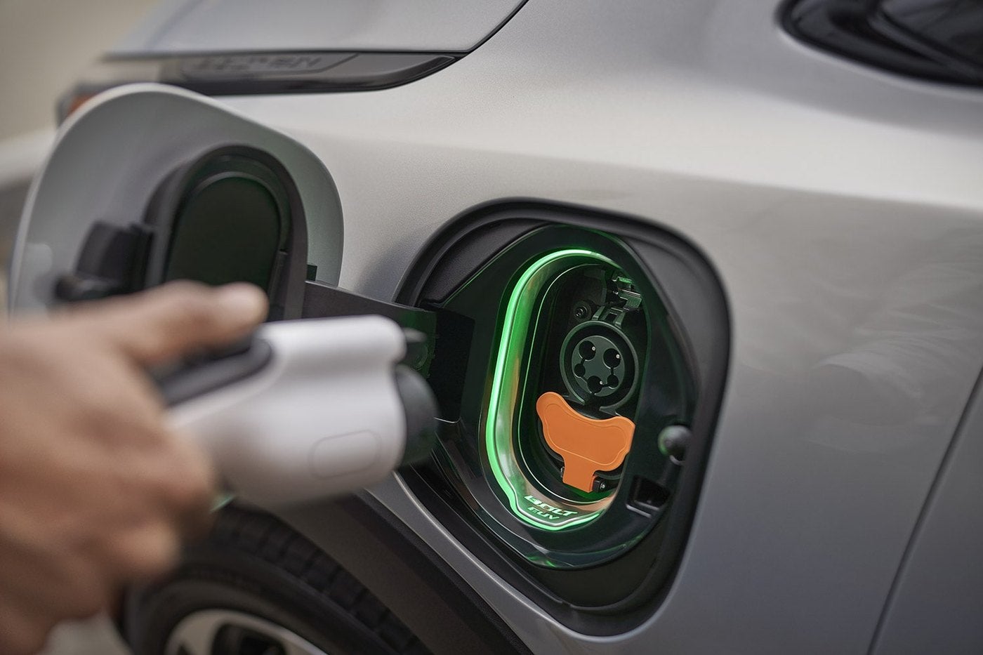 Charging connector plugged into a Chevrolet electric vehicle charge port with a green light ring