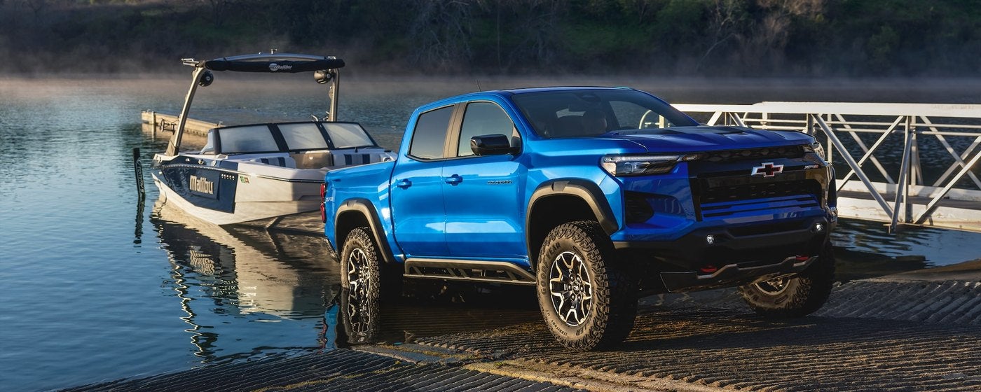 Blue Chevrolet Colorado pulling a boat out of the water at a ramp