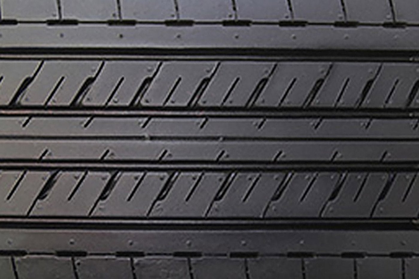 Close view of a tire with fine highway tread grooves