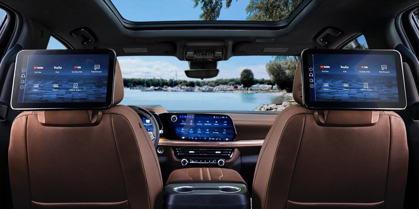Chevrolet Suburban interior with brown leather front seats and two rear seat entertainment screens