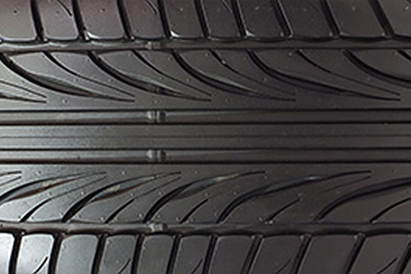 Close view of a tire with directional tread grooves