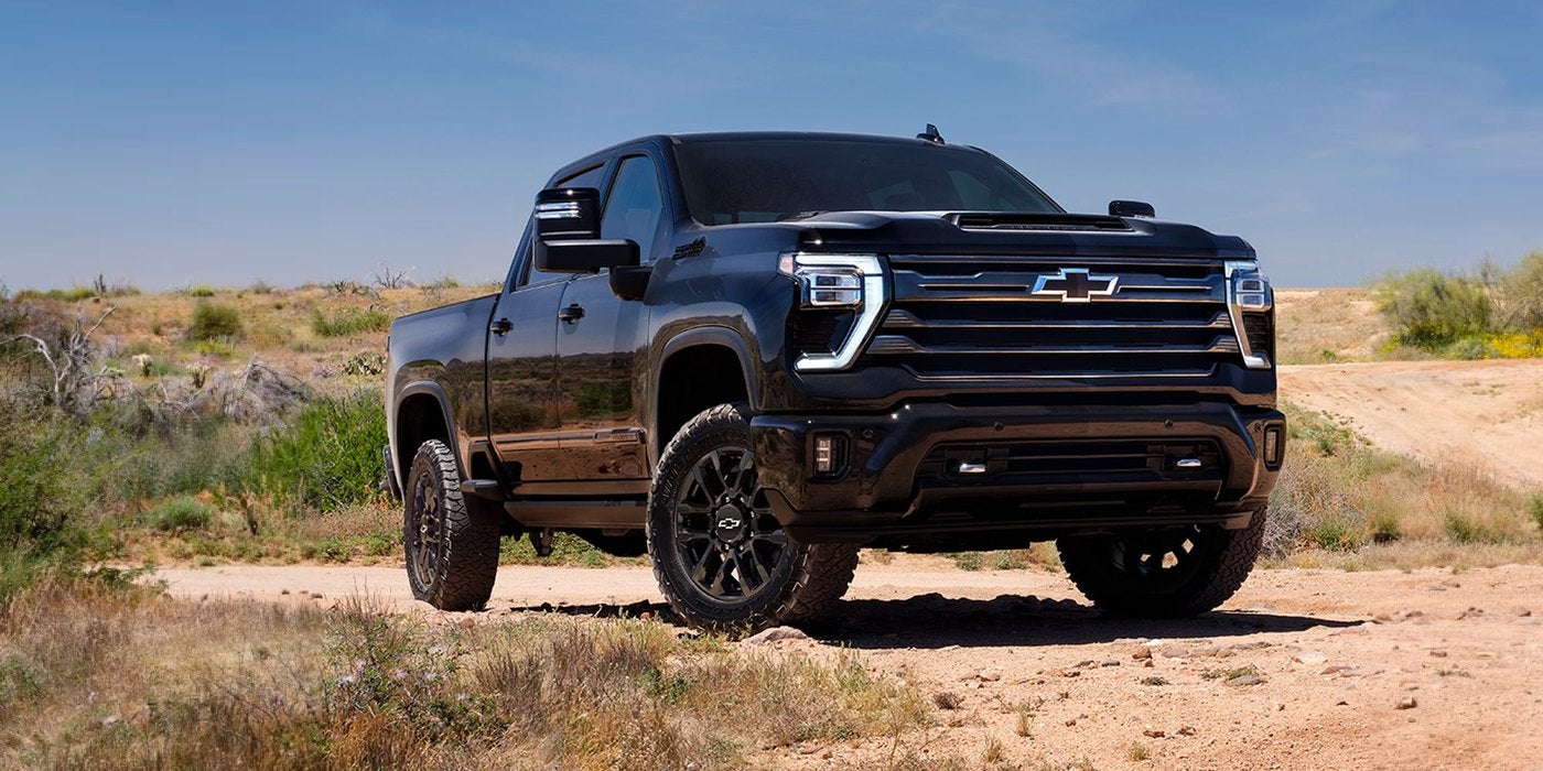 Black Silverado HD crew cab parked on a dirt trail in dry scrub country