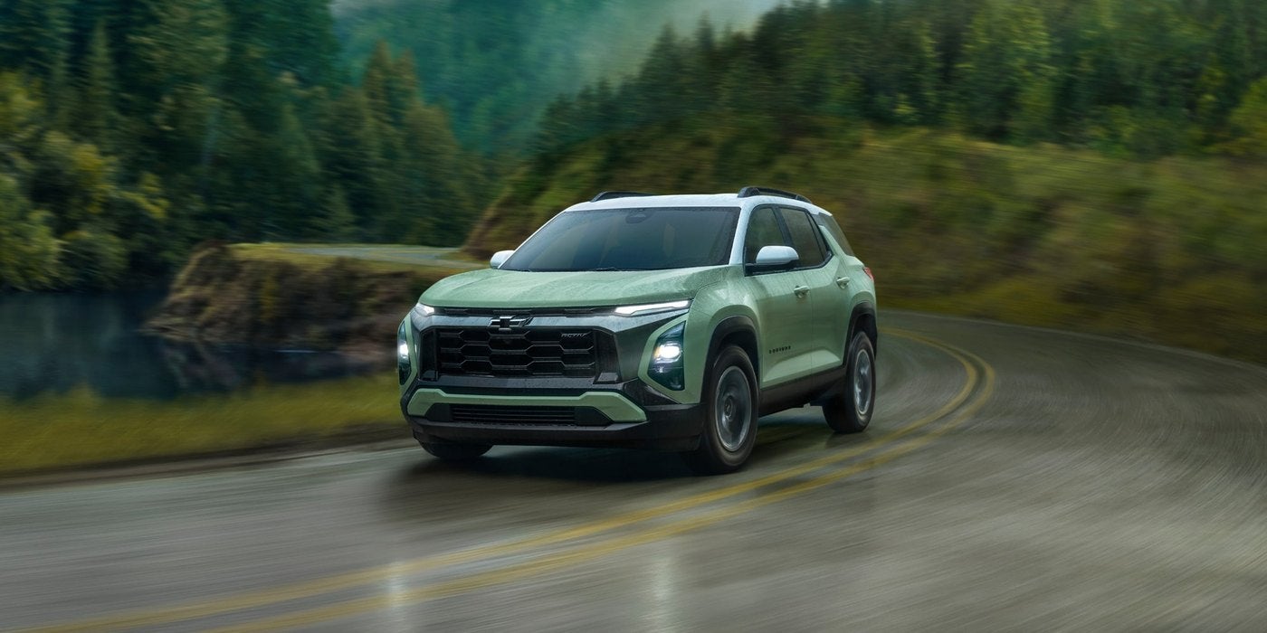 Green Chevrolet Equinox taking a curve on a forest road